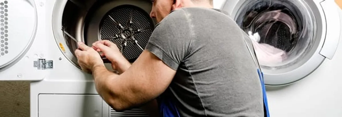 Dryer repair technician fixing a clothes dryer drum in Cleveland, OH