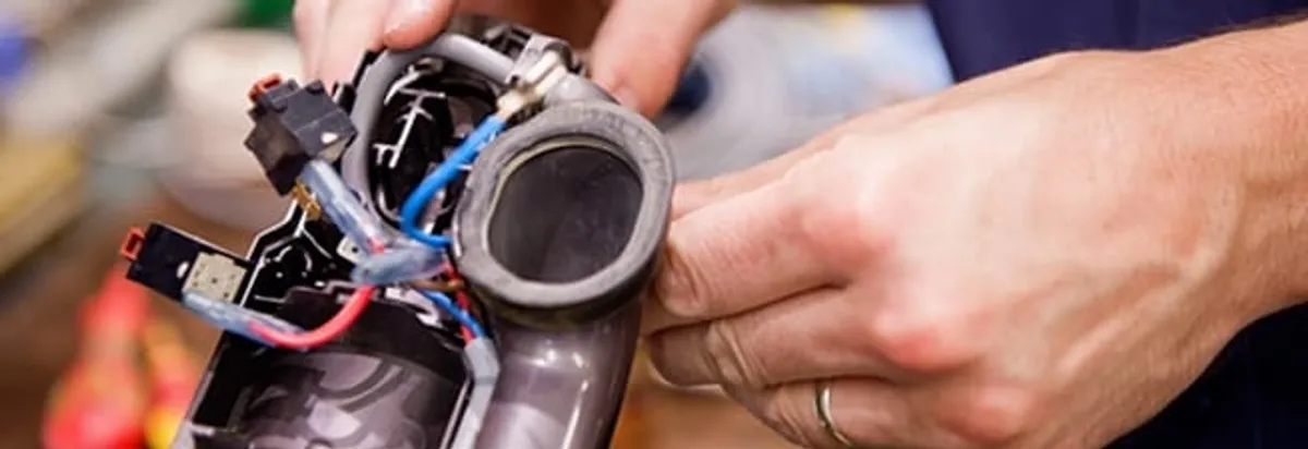 Vacuum repair technician reconnecting wiring and components in Cleveland, OH