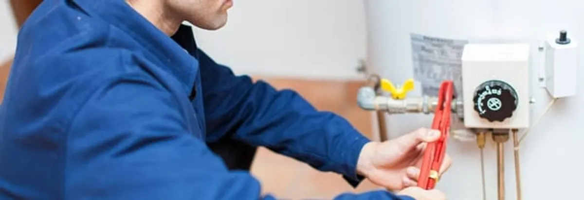 Water heater repair technician adjusting the temperature control and gas valve in Cleveland, OH